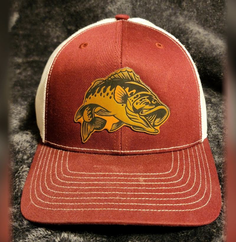 Maroon and white trucker hat with a laser-engraved leather patch cut in the shape of a largemouth bass